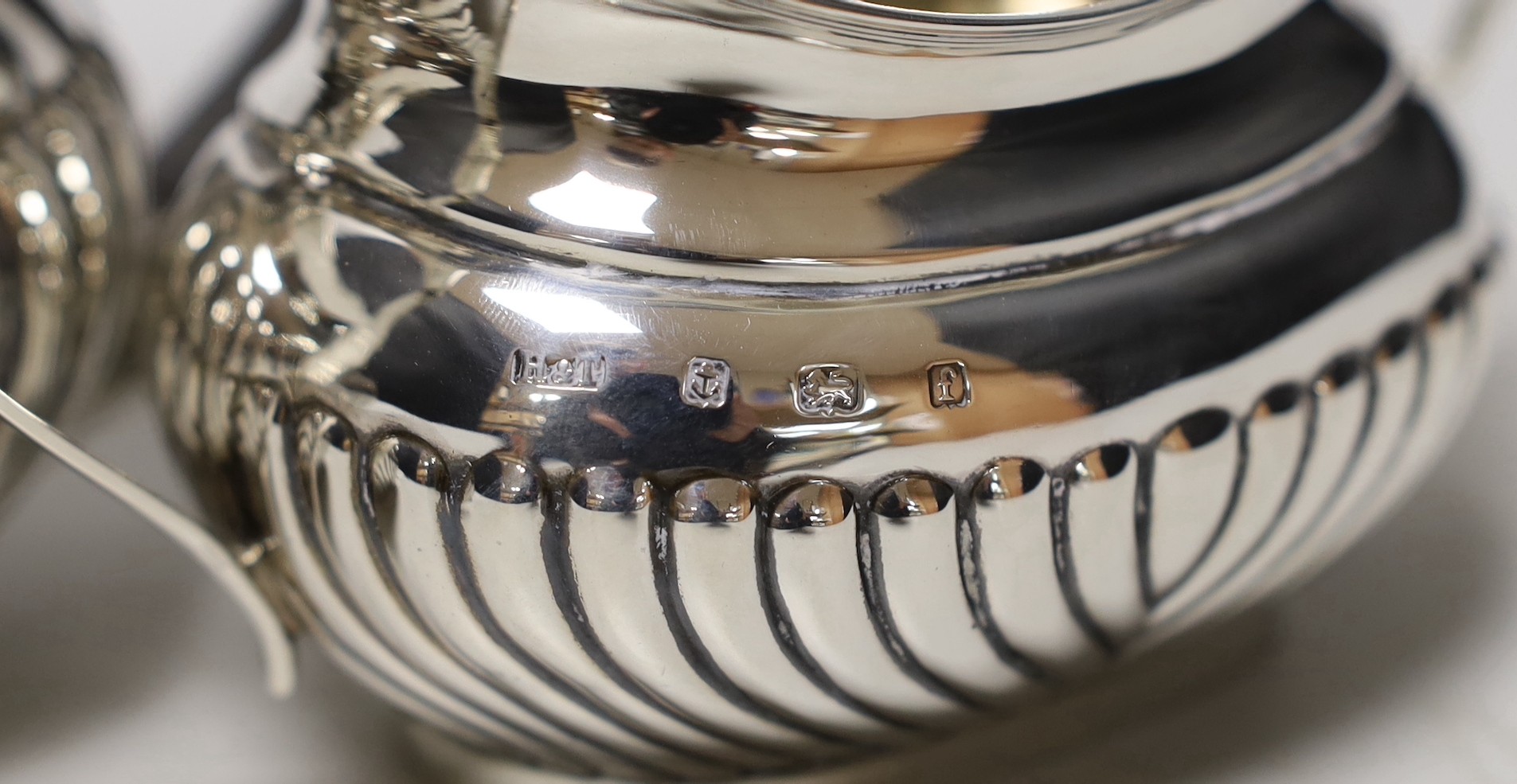 An Edwardian three piece demi-fluted silver tea set, Birmingham, 1905, gross 21.1oz.